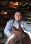 A girl riding on the back of a horse.